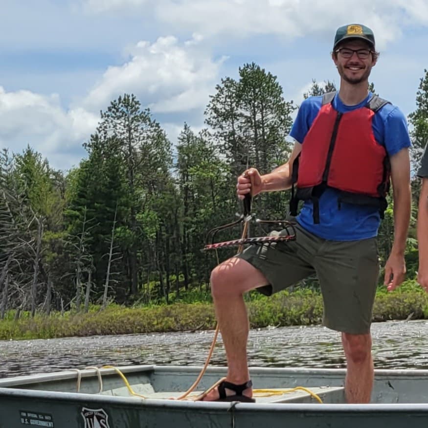 Erick on a USFS boat with plant rake